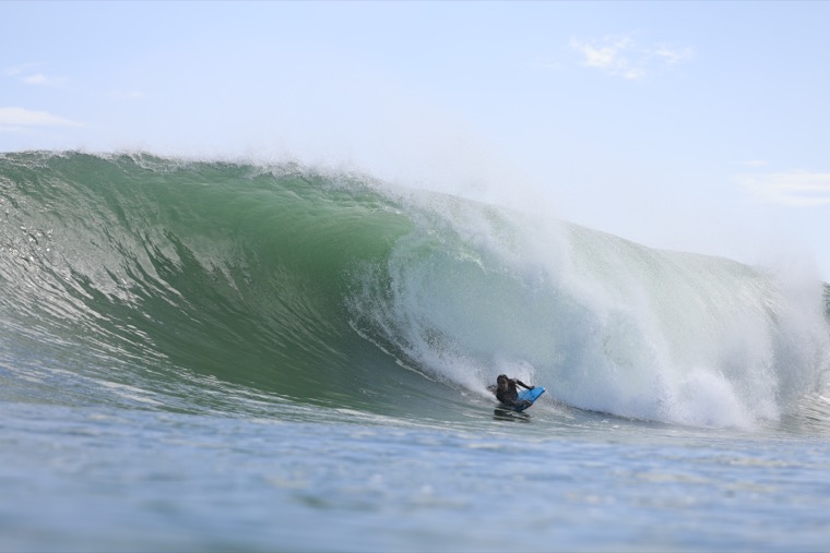 Anne-Cécile in a large green wave.