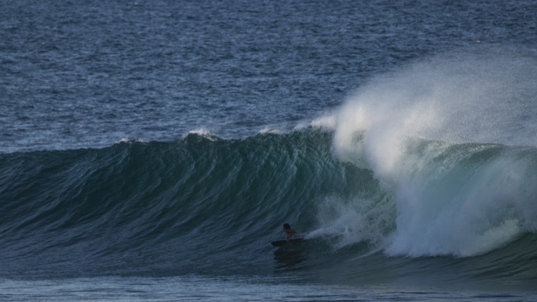Bodyboarding in a dark, powerful wave.