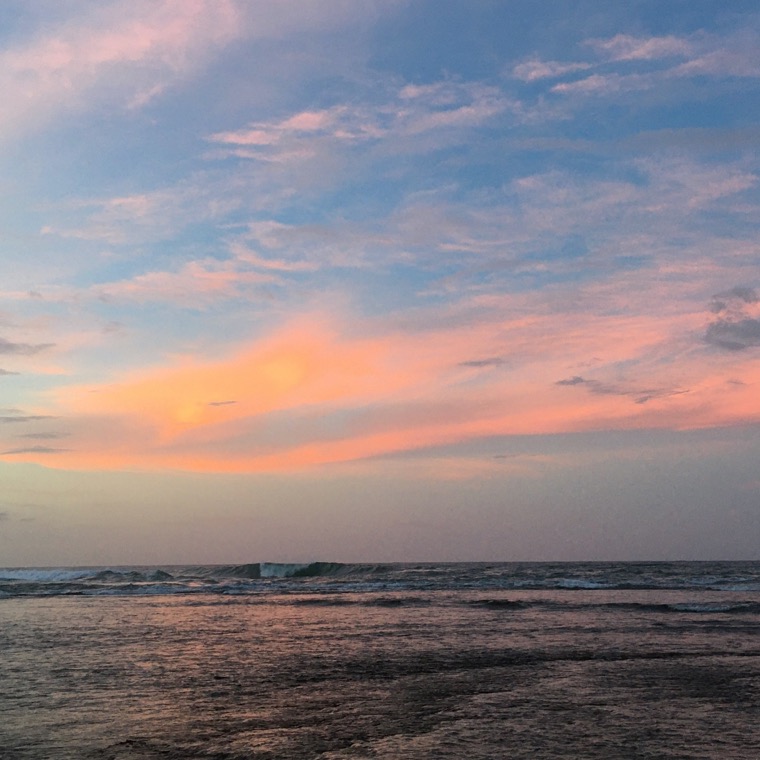 Ocean under a pink sky.